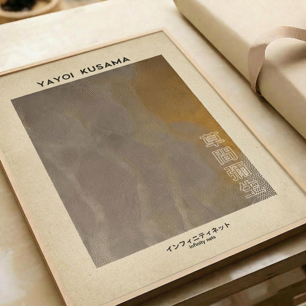 A minimalist art print with a textured dotted pattern in muted brown and beige tones, featuring Japanese text characters in the corner. The artwork is displayed on cream-colored paper with a white border, lying flat on a neutral surface next to rolled paper tubes. The piece has a subtle, organic stippled texture throughout and includes both English and Japanese text at the bottom.