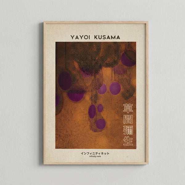 May include: Framed art print displaying abstract composition with orange background, purple polka dots and circular shapes, intricate dotted textures throughout. Features "YAYOI KUSAMA" text at top and Japanese characters on right side, with "infinity nets" subtitle at bottom. Light wood frame with cream matting, mounted on white wall.