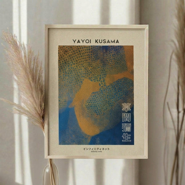 May include: Framed art print displayed on neutral wall next to dried pampas grass in glass vase. Print features abstract dotted pattern in blue, orange and yellow tones with Japanese text. Light wood frame with cream matting, soft natural lighting, minimalist home decor setting.