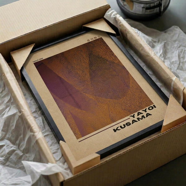 May include: Framed abstract art print with warm orange and purple gradients in dotted pattern texture, displayed in black frame inside cardboard shipping box with protective tissue paper wrapping on white surface