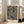 May include: Framed black and white abstract art print leaning against white wall in bright living room. The artwork features flowing wavy lines and scattered dots in Kusama's signature style, with "YAYOI KUSAMA" text at top and Japanese characters below. Light wood frame, positioned next to beige upholstered chair near large windows with natural light streaming in.