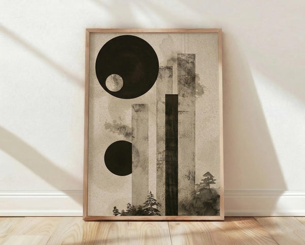 May include: Abstract art print in wooden frame leaning against white wall on light wood floor. Artwork features geometric design with large black circle containing smaller light circle, half black circle below, vertical rectangular bars in muted tones, and silhouetted evergreen trees at bottom. Beige textured background with subtle aging effects. Natural lighting creates soft shadows on wall.