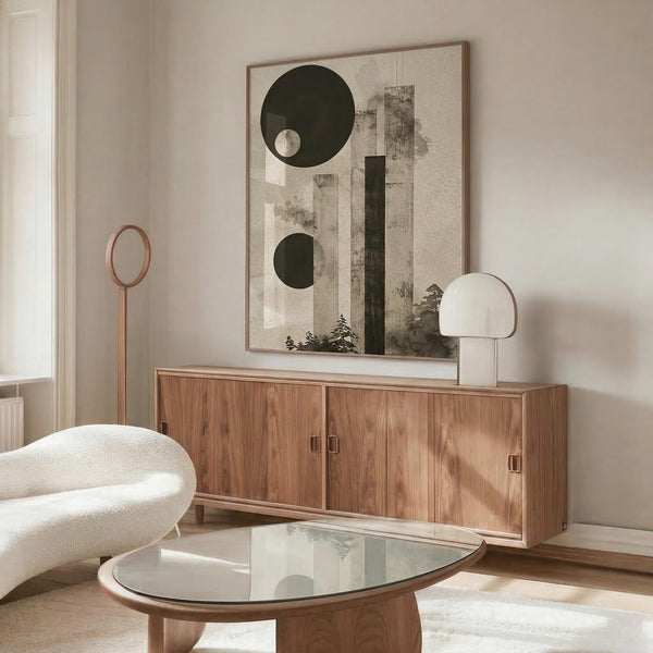 May include: Abstract poster print featuring dark green circles and geometric shapes with weathered vertical bars and small silhouettes of pine trees against a neutral beige background. Shown in thin wood frame above walnut credenza in modern living room with white curved chair, glass coffee table, and copper floor lamp.