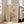 May include: Framed minimalist art print leaning against white wall beside beige sofa in bright living room. Artwork features black bare tree silhouette against warm beige background with geometric shapes - small red circle, larger tan circle, and curved tan forms. Natural light streams through windows onto light wooden floors.