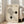 May include: Framed Bauhaus-inspired poster with geometric design featuring curved lines forming an abstract shape, two dark circles, and "BAUHAUS 1919" text on cream background with German text below. Light wood frame leaning against white wall next to beige sofa in bright, minimalist living room with large windows.