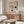 May include: Vintage-style Bauhaus poster with geometric design featuring curved lines and black circles on cream background, displayed above wooden sideboard in minimalist room with white chair, glass coffee table, and neutral decor