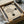 May include: Cream-colored poster with black geometric design featuring curved and straight lines forming an abstract shape, displayed in black frame inside cardboard shipping box with protective wrapping materials and wooden dowels for packaging