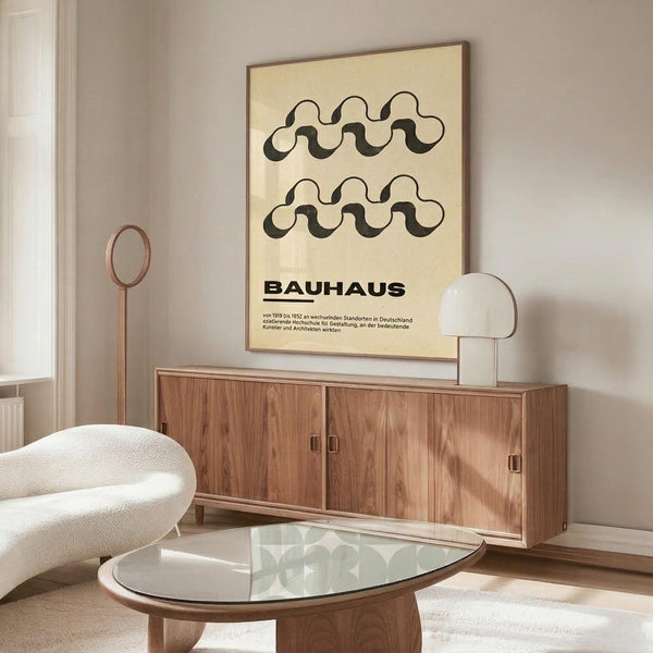 May include: Framed Bauhaus poster with wavy black lines on cream background hanging above wooden sideboard in minimalist living room with white textured chair, glass coffee table, and modern table lamp
