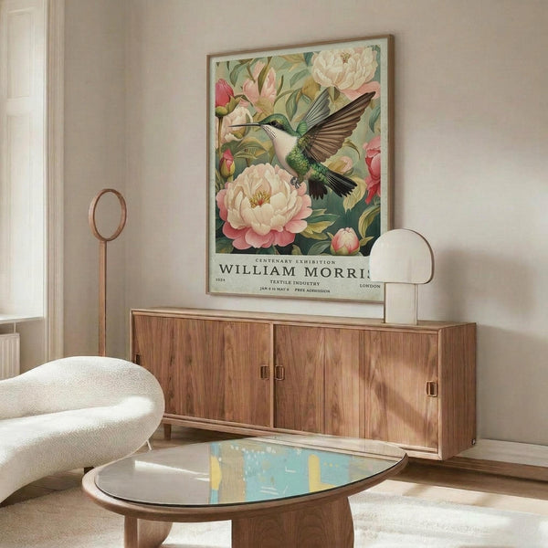 May include: Framed botanical poster featuring green hummingbird with spread wings among pink and white peonies and roses on sage background, displayed above walnut sideboard in modern living room with cream swivel chair, oval glass coffee table, and white table lamp
