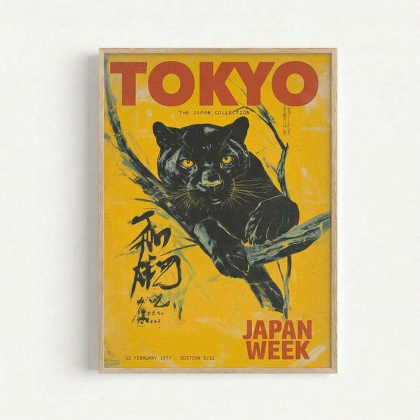 Vintage-style poster with bright yellow background featuring a black panther with golden eyes perched on tree branches. Red text reads "TOKYO" at top and "JAPAN WEEK" at bottom, with Japanese characters on the left side. The artwork has a weathered, distressed appearance and is displayed in a simple light wood frame against a white wall.