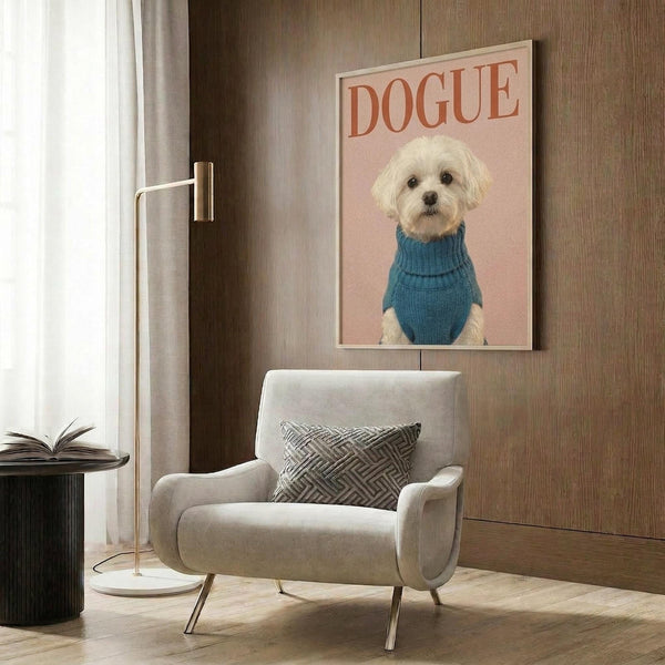 May include: Framed poster featuring a small white Maltese dog wearing a blue knit turtleneck sweater against a pink background with "DOGUE" text in coral letters, displayed above a beige upholstered armchair with geometric patterned pillow in a modern living room with wood paneled walls, floor lamp, and side table with open book.