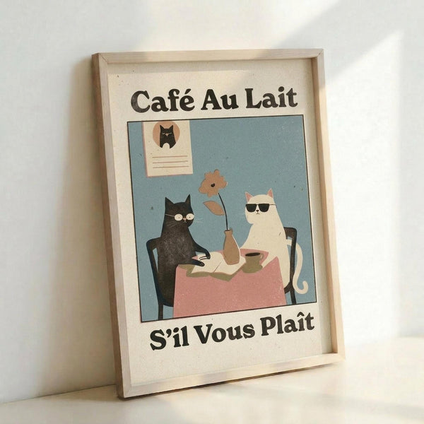 May include: Framed vintage-style poster print leaning against white wall. Features two cats at cafe table - black cat with glasses and white cat with sunglasses - sharing coffee and pastries. Pink tablecloth, blue background, cat portrait on wall. French text "Café Au Lait" and "S'il Vous Plaît" in black letters. Light wood frame, cream colored paper with speckled texture.