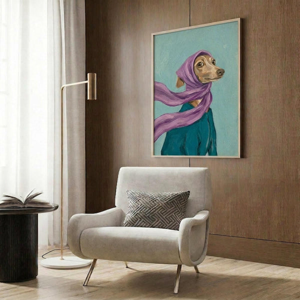 May include: Framed artwork showing an Italian Greyhound wearing a purple head scarf and teal garment against a mint green background, displayed on wood paneled wall above a beige upholstered armchair with geometric patterned pillow. Modern living room setting with brass floor lamp and side table with open book.
