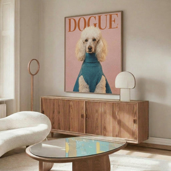 May include: Framed poster featuring a cream-colored poodle wearing a teal turtleneck sweater against a soft pink background, with "DOGUE" text at top in orange letters. Displayed on a walnut wood sideboard in a modern living room with white upholstered chair, glass coffee table, and neutral decor.