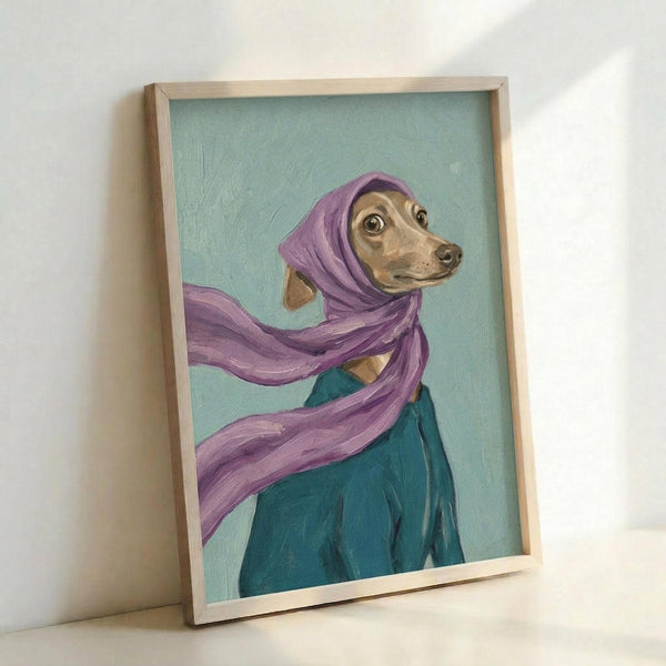 May include: Framed painting of a tan Italian Greyhound wearing a flowing purple headscarf and teal garment against a mint green background. The artwork shows visible brushstrokes and is displayed in a light wooden frame, leaning against a white wall. The dog has large dark eyes and is positioned in a three-quarter view portrait style.