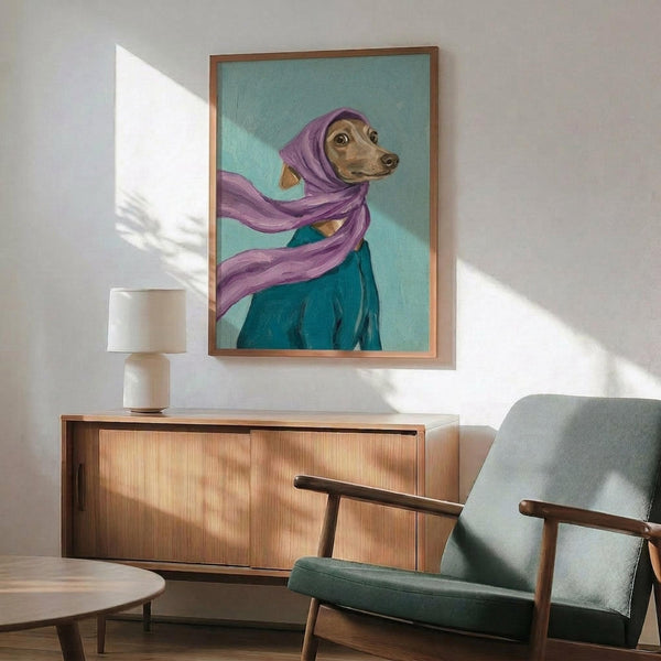 May include: Framed artwork showing an Italian Greyhound wearing a purple headscarf and teal garment against a mint green background, displayed above a wooden sideboard with lamp in a mid-century modern living room with gray upholstered chair and natural lighting casting geometric shadows on white walls.