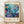 May include: Framed poster with vibrant underwater scene featuring colorful fish, coral, and sea plants in blues, purples, oranges and greens. Text shows Japanese characters and "JAPAN 1984" with museum attribution. Light wood frame against white textured wall on wooden floor with soft shadows.