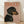 May include: Framed poster print featuring a black and tan dachshund wearing a sparkly rhinestone collar against a dusty pink background, with "DOGUE" in large orange serif letters across the top. The wooden frame sits on light hardwood flooring against a white wall with soft natural lighting creating diagonal shadows.