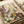 May include: Colorful botanical art print with dotted pattern style featuring wildflowers, daisies, leaves and abstract plant forms in purple, yellow, orange and green tones. Print shown flat on white paper with cream ribbon nearby, displaying detailed stippled texture and whimsical meadow design.