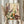 May include: Person in cream ruffled sleeves holding framed botanical art print and dried pampas grass against white curtained window. The artwork features dotted wildflowers, daisies, and plants in purple, yellow, green, and orange colors with pointillism-style dots throughout. Natural lighting creates soft shadows on the cream-colored wall.