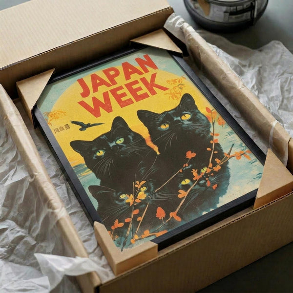 May include: Framed vintage-style poster featuring three black cats with bright yellow and green eyes against autumn sunset sky. Red "JAPAN WEEK" text at top, orange maple branches in foreground, silhouetted bird in flight. Warm yellow, orange and teal color palette with retro travel poster aesthetic. Frame packed in cardboard shipping box with protective paper wrapping on white tissue paper background.