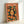 May include: Framed poster with orange and green design featuring a woman with long dark hair surrounded by oranges, orange slices, and leaves. The poster displays "TOKYO - JAPAN" at the top with Japanese characters on the right side. Art print shown in light wood frame leaning against white wall, displaying vintage travel poster aesthetic with warm orange background and botanical citrus motifs.