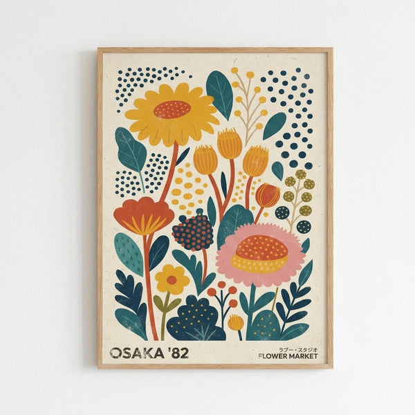 May include: A framed botanical art print on a white wall featuring stylized flowers in retro mid-century modern style. The artwork displays colorful blooms including yellow sunflowers, pink and orange daisies, blue dotted elements, and teal leaves on cream background. Natural wood frame surrounds the vintage-inspired floral illustration with "OSAKA '82 FLOWER MARKET" text at bottom.
