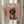 May include: Framed poster with coral pink background featuring a black and tan dachshund wearing a pink chef's hat and floral apron, styled as a fashion magazine cover with "DOGUE" in large cream letters at top. Light wood frame displayed on white wall next to dried wheat stems and flowing curtains.