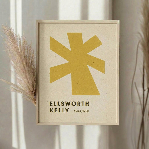 May include: Framed art print with yellow geometric star shape on cream textured background, displayed on wall next to dried pampas grass stems in neutral bohemian interior setting with natural lighting and beige curtains