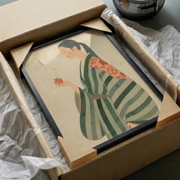 May include: Framed artwork showing a Japanese woman in traditional green and cream striped kimono with coral floral obi sash, depicted in minimalist illustration style on cream background. Black frame partially visible in cardboard shipping box with protective wrapping materials and wooden dowels nearby.