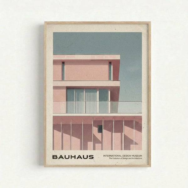 May include: Framed architectural poster showing modernist building facade with pink and coral tones, geometric windows, vertical slats on ground level, and pale blue-green sky background. Light wood frame with cream matting, displayed on white wall. Clean minimalist presentation with Bauhaus and International Design Museum text at bottom.