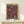 May include: Framed vintage-style poster with bold pink sunflower-like blooms and white polka dots on black background, displayed on light wood console table next to small wrapped gift box with evergreen sprig. The poster features "JAPAN WEEK" text and Japanese characters, housed in natural wood frame against white wall.