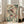 May include: Large framed vintage-style illustration of two detailed fish with coral-pink fins swimming among green aquatic plants and bubbles, displayed in light wooden frame leaning against white wall next to beige armchair in bright living room with hardwood floors and tall windows