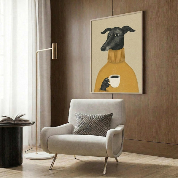 May include: Framed artwork showing a black greyhound wearing a mustard yellow turtleneck sweater and holding a white coffee cup, displayed above a beige upholstered armchair with geometric pillow in a modern living room with wood paneling, floor lamp, and side table with open book.