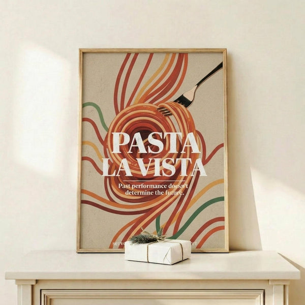 May include: Retro-style poster with colorful swirling pasta noodles in red, orange, yellow and green tones on beige background, featuring "PASTA LA VISTA" text and "Past performance doesn't determine the future" subtitle. Black fork twirls orange spaghetti. Displayed in natural wood frame on white shelf next to small wrapped gift with evergreen sprig.