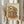 May include: Hands holding a framed illustration of a cozy two-story Japanese ramen shop with warm wood exterior, orange lanterns, outdoor seating with stools, potted plants, and Japanese text signage. The artwork has vintage beige tones and detailed architectural elements including traditional roof tiles and power lines. Dried wheat stalks visible to the left side.