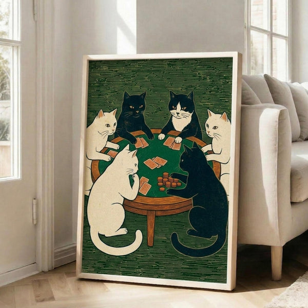 May include: Framed poster print displayed in bright living room showing six cats sitting around green card table playing poker. White and black cats hold playing cards with poker chips on table. Artwork features vintage woodblock print style with green textured background. Light wood frame leans against white wall near beige upholstered chair and large windows with natural sunlight streaming in.