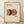 May include: Framed poster with cream background featuring abstract geometric design of overlapping circles in coral pink, rust orange, and dark charcoal colors with three small black dots below. Natural wood frame displayed on light wooden floor against white wall with soft shadows.