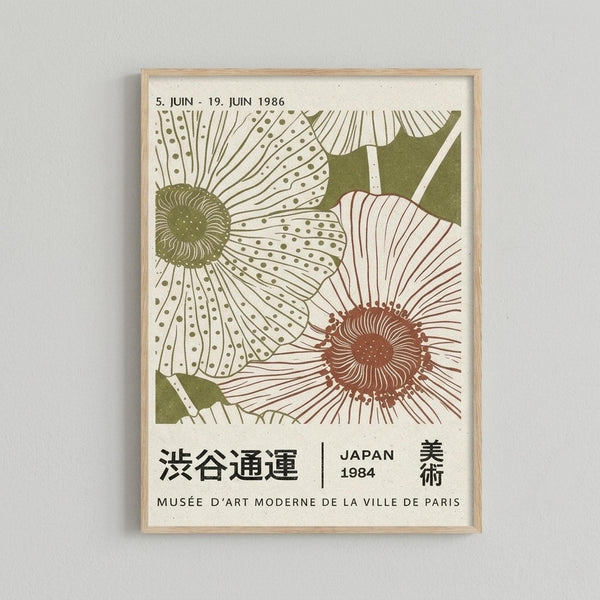 May include: A framed poster print displaying two large stylized flowers with detailed petals and centers in green and reddish-brown colors. The artwork shows Japanese text and dates from 1984 and 1986, with "Musée d'Art Moderne de la Ville de Paris" at the bottom. The print is mounted in a light wood frame and displayed against a white wall.