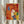 May include: Framed colorful dog illustration artwork displayed on white surface with dried pampas grass and beige fabric. Print features four stylized dogs in vibrant orange, blue, yellow, and white colors against warm red and orange background with textured brushstroke effects. Light wooden frame catches natural window light in neutral home setting.