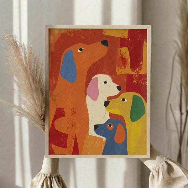May include: Framed colorful dog illustration artwork displayed on white surface with dried pampas grass and beige fabric. Print features four stylized dogs in vibrant orange, blue, yellow, and white colors against warm red and orange background with textured brushstroke effects. Light wooden frame catches natural window light in neutral home setting.