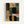 Framed abstract geometric artwork with overlapping black rounded rectangles on a background of colorful translucent squares and rectangles in orange, blue, teal, coral, olive, and gray tones. The piece has a textured, painted appearance and is displayed in a light wood frame against a white wall.
