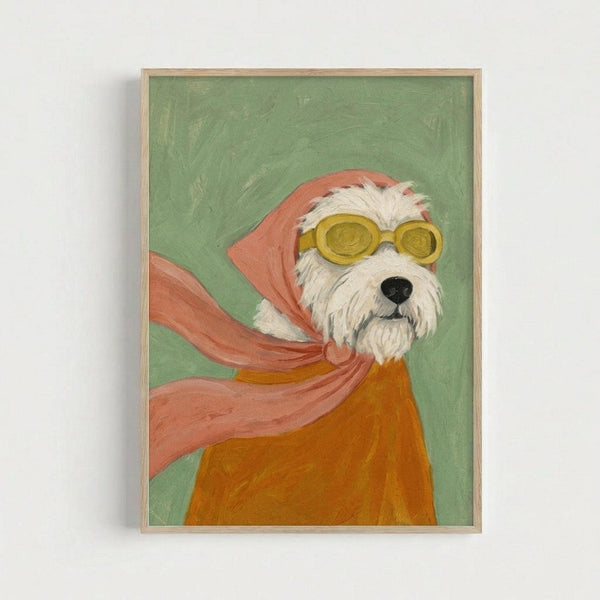 A whimsical painted portrait of a small white fluffy terrier wearing round yellow goggles and a flowing coral-pink scarf against a sage green background. The dog appears in an orange sweater or coat, with the scarf billowing dramatically around its head and neck. The artwork has visible brushstrokes and a folk art style, displayed in a light wooden frame against a white wall.