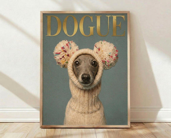 May include: Framed poster print featuring an Italian Greyhound wearing a cream knitted sweater with colorful pom-pom ear warmers against a sage green background. Gold "DOGUE" text appears at top in fashion magazine style. Natural wood frame sits on light wooden floor against white wall with soft shadows.