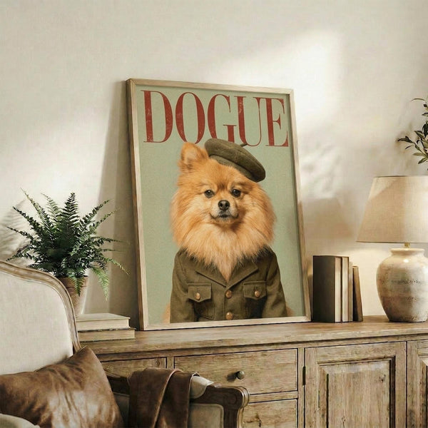 May include: Framed poster featuring orange Pomeranian dog wearing olive green military uniform and beret against mint background, with "DOGUE" in red letters at top. Displayed on rustic wooden sideboard alongside fern plant, ceramic vase, and stacked books in neutral living room setting with beige chair visible.