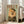 May include: Framed poster print featuring a fluffy orange Pomeranian dog wearing an olive green military-style jacket and matching beret against a mint green background, with "DOGUE" text in red vintage lettering at top. White wooden frame displayed on light hardwood floor next to beige upholstered chair in bright, windowed living room setting.