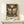 May include: Framed vintage-style botanical poster featuring large butterfly with cream and olive green patterned wings surrounded by wildflowers on dark background, displayed on light wood console table with small wrapped gift, against cream wall with natural lighting