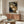 May include: Two spotted leopard cats with closed eyes nestled together, rendered in traditional Japanese woodblock print style with golden fur, black spots, and dark blue patterned background. Wall art displayed above a wooden credenza in modern living room with white curved chair, round glass coffee table, and warm natural lighting.