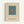 A framed minimalist art print featuring a teal blue square with a small orange square centered within it, displayed on a cream-colored background. The print includes "ELLSWORTH KELLY" and "LOS ANGELES, CALIFORNIA" text at the bottom. The artwork is housed in a thin natural wood frame and mounted against a white wall.