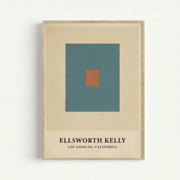 A framed minimalist art print featuring a teal blue square with a small orange square centered within it, displayed on a cream-colored background. The print includes "ELLSWORTH KELLY" and "LOS ANGELES, CALIFORNIA" text at the bottom. The artwork is housed in a thin natural wood frame and mounted against a white wall.